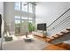 Bright living room boasts soaring ceilings, large windows, hardwood floors, and a modern staircase at 1253 Caroline Ne St # 223, Atlanta, GA 30307