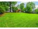 Expansive backyard with lush green grass, mature trees, and a two-story home at 2045 Bethany Spring Trce, Cumming, GA 30041