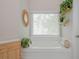 Bright bathroom with a soaking tub, window with blinds, and plants on shelves at 2045 Bethany Spring Trce, Cumming, GA 30041