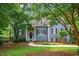 Charming home featuring stone accents, gray siding, lush landscaping and a welcoming front porch at 2045 Bethany Spring Trce, Cumming, GA 30041