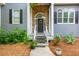 Inviting entrance with a stone archway, stylish door, and charming landscaping at 2045 Bethany Spring Trce, Cumming, GA 30041