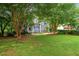 A charming home with beautiful landscaping, mature trees, and a lush green lawn at 2045 Bethany Spring Trce, Cumming, GA 30041