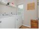 Functional laundry room with washer, dryer, shelving, and a window for natural light at 2045 Bethany Spring Trce, Cumming, GA 30041