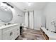 Clean bathroom with vinyl floor, single sink vanity, toilet, shower with curtains, and shelving at 402 Homestead Dr, Dallas, GA 30157