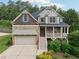 Charming two-story home featuring a stone facade, covered porch, and an attached two-car garage at 402 Homestead Dr, Dallas, GA 30157