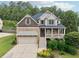 Charming two-story home featuring a stone facade, covered porch, and an attached two-car garage at 402 Homestead Dr, Dallas, GA 30157