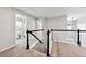 Hallway featuring carpet flooring, white railings with black trim, and bathroom access at 402 Homestead Dr, Dallas, GA 30157