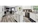 Open concept kitchen with views to the living room, white cabinetry, and stainless appliances at 402 Homestead Dr, Dallas, GA 30157