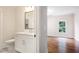 This bathroom boasts a white vanity with modern fixtures and a sleek mirror adjacent to an entry to the bedroom at 11 Brownson Ct, Acworth, GA 30101