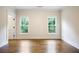This bright bedroom features hardwood floors, crown molding, and two windows looking out onto a lush green landscape at 11 Brownson Ct, Acworth, GA 30101