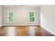 This bright bedroom features hardwood floors, crown molding, and two windows looking out onto a lush green landscape at 11 Brownson Ct, Acworth, GA 30101