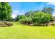 Expansive community lawn with lush green grass and mature trees offers a serene outdoor space at 2300 Peachford Rd # 2404, Atlanta, GA 30338