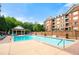 Outdoor pool with surrounding lounge chairs and nearby building at 2300 Peachford Rd # 2404, Atlanta, GA 30338