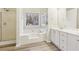 Well-lit bathroom features double sink vanity, separate shower, soaking tub and window at 245 London Ln, Hiram, GA 30141