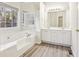 Bright bathroom featuring double vanity, soaking tub, and tile flooring at 245 London Ln, Hiram, GA 30141
