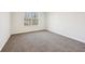 Simple bedroom with neutral walls and carpet, brightened by a window view at 245 London Ln, Hiram, GA 30141