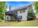 Exterior rear view of home featuring deck with stairs and large windows providing ample natural light at 245 London Ln, Hiram, GA 30141