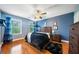 This bedroom features hardwood floors, blue walls, ceiling fan and natural light at 360 Glade Knoll Trail Trl, Fayetteville, GA 30215