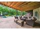 Covered outdoor patio with comfortable seating, a pool view, and wooded backdrop at 360 Glade Knoll Trail Trl, Fayetteville, GA 30215