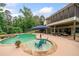 Inviting backyard pool with a tanning ledge, in-ground hot tub, and covered patio seating area at 360 Glade Knoll Trail Trl, Fayetteville, GA 30215