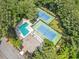 Overhead view of a shared pool and tennis courts, both surrounded by lush trees offering a private recreational escape at 545 Matterhorn Way Way, Alpharetta, GA 30022