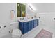 Bright bathroom boasts double vanity with blue cabinets, neutral counter and modern fixtures at 545 Matterhorn Way Way, Alpharetta, GA 30022