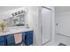 Bathroom features a vanity with blue cabinets and a shower with glass door at 545 Matterhorn Way Way, Alpharetta, GA 30022
