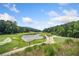 Picturesque view of the golf course with lush greenery, a tranquil pond, and rolling hills at 545 Matterhorn Way Way, Alpharetta, GA 30022