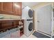 Functional laundry room with stacked washer and dryer and wooden cabinets at 545 Matterhorn Way Way, Alpharetta, GA 30022