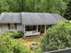 Cozy single-story home with a charming front porch and lush greenery in the yard at 6305 Eidson Dr, Cumming, GA 30041