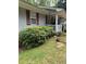 Charming home featuring light gray siding, red shutters, a covered front porch, and well-maintained landscaping at 6305 Eidson Dr, Cumming, GA 30041
