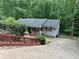 Charming single-story home with light siding, red shutters, and lush green trees surrounding the property at 6305 Eidson Dr, Cumming, GA 30041