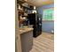 Compact kitchen with modern black appliances, sleek gray cabinets, and a laminate floor at 6305 Eidson Dr, Cumming, GA 30041
