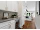 Stylish kitchen with a wine cooler, white cabinets, and gold hardware at 2493 Oostanaula Ne Dr, Brookhaven, GA 30319