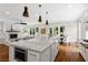 Open kitchen and living space with stainless appliances, a fireplace, and large island at 2493 Oostanaula Ne Dr, Brookhaven, GA 30319