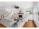 Cozy living room with stairs, fireplace, ceiling fan, and large windows at 2493 Oostanaula Ne Dr, Brookhaven, GA 30319