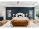 Elegant primary bedroom with a decorative wall, hardwood floors, and modern furniture at 2493 Oostanaula Ne Dr, Brookhaven, GA 30319