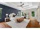 Stylish primary bedroom with a tray ceiling, decorative wall, and large windows at 2493 Oostanaula Ne Dr, Brookhaven, GA 30319
