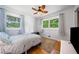 Bright bedroom featuring hardwood floors, two large windows, a ceiling fan and light blue walls at 3190 Crestview Circle Nw Cir, Duluth, GA 30096