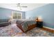 Bright main bedroom with ceiling fan, colorful rug, and large window with natural light at 3190 Crestview Circle Nw Cir, Duluth, GA 30096