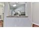 View of the kitchen through a pass through featuring white cabinets and granite countertops at 3334 Peachtree Ne Rd # 614, Atlanta, GA 30326