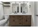 Well-lit bathroom with a wooden double vanity, white countertops, and a shower with a tiled surround at 5147 Manerdale Se Dr # 5, Vinings, GA 30339