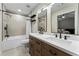 Modern bathroom with double sinks, white countertops, wood cabinets, and shower-tub combination at 5147 Manerdale Se Dr # 5, Vinings, GA 30339