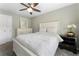 Neutral bedroom featuring a ceiling fan, white bedspread, and elegant dark wood nightstand at 5147 Manerdale Se Dr # 5, Vinings, GA 30339