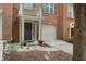 Charming brick townhouse with a two-car garage, a welcoming entryway, and fresh landscaping at 5147 Manerdale Se Dr # 5, Vinings, GA 30339