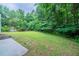 Lush backyard with tall trees and green grass, and patio space with ample room for outdoor activities at 621 Lakewater View Dr, Stone Mountain, GA 30087
