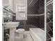 Bathroom features a white tile floor, black tiled walls, and a window for natural light at 821 Erin Sw Ave, Atlanta, GA 30310
