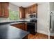 Kitchen with dark counters, wooden cabinets, stainless microwave and a black gas stove at 821 Erin Sw Ave, Atlanta, GA 30310