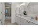 Bathroom featuring a double vanity with large mirrors, white cabinets, and a tiled shower at 1012 Chestnut Creek Dr, Villa Rica, GA 30180