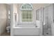 Bathroom featuring a soaking tub, separate glass shower, and large window for natural light at 1012 Chestnut Creek Dr, Villa Rica, GA 30180